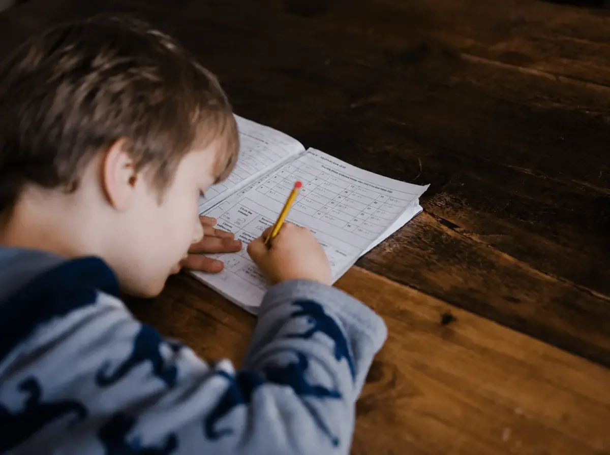 Boy doing homework with a notebook and pencil