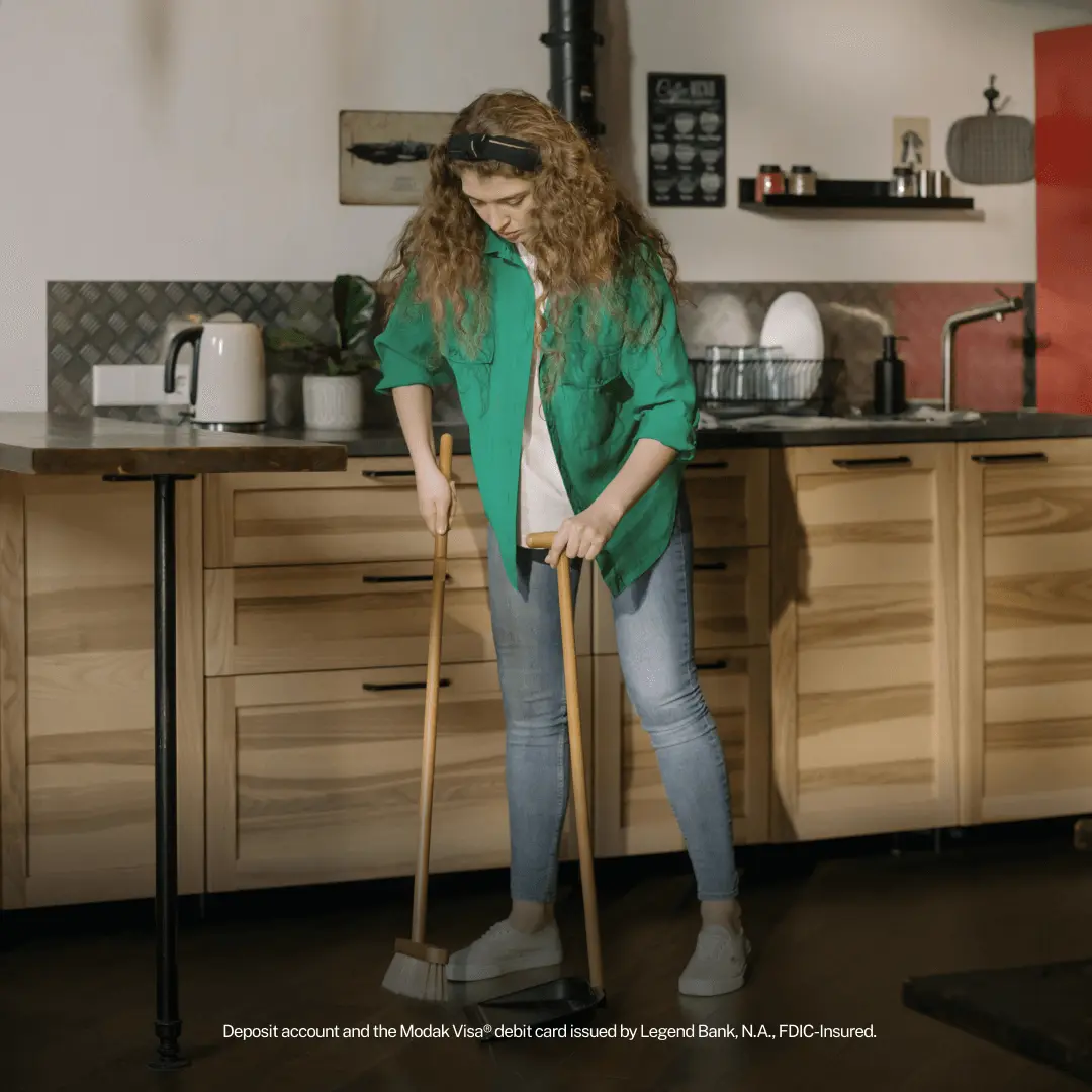 Teen sweeping a kitchen floor with a broom
