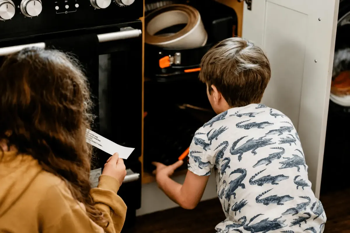 Two kids reading a note by an open oven