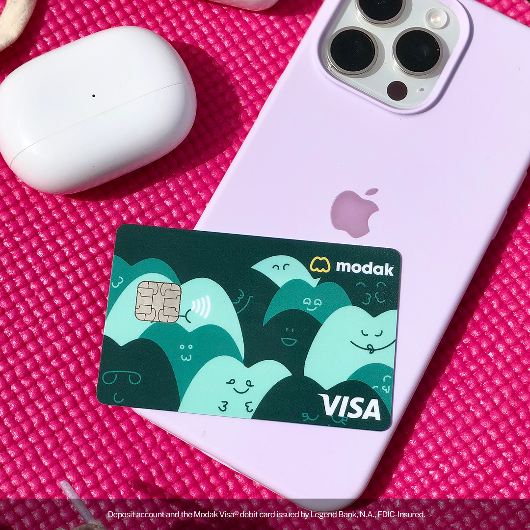 Modak Visa debit card resting on a phone