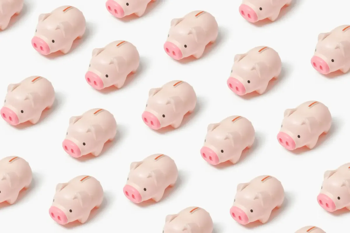repeating pattern of small pink piggy banks on a white background
