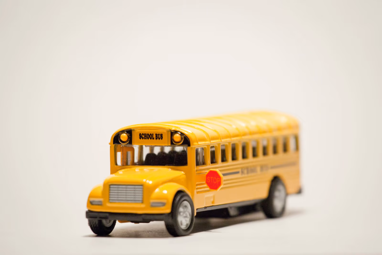 Toy yellow school bus with a STOP sign, close up