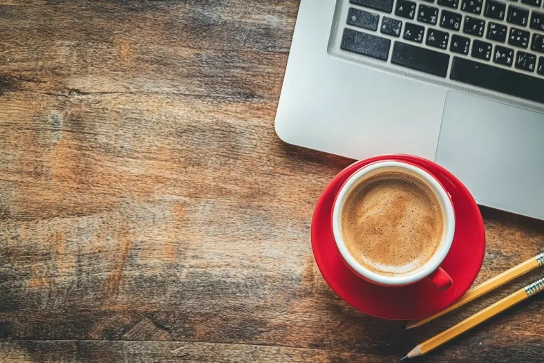 laptop over a wooden table next to a coffee